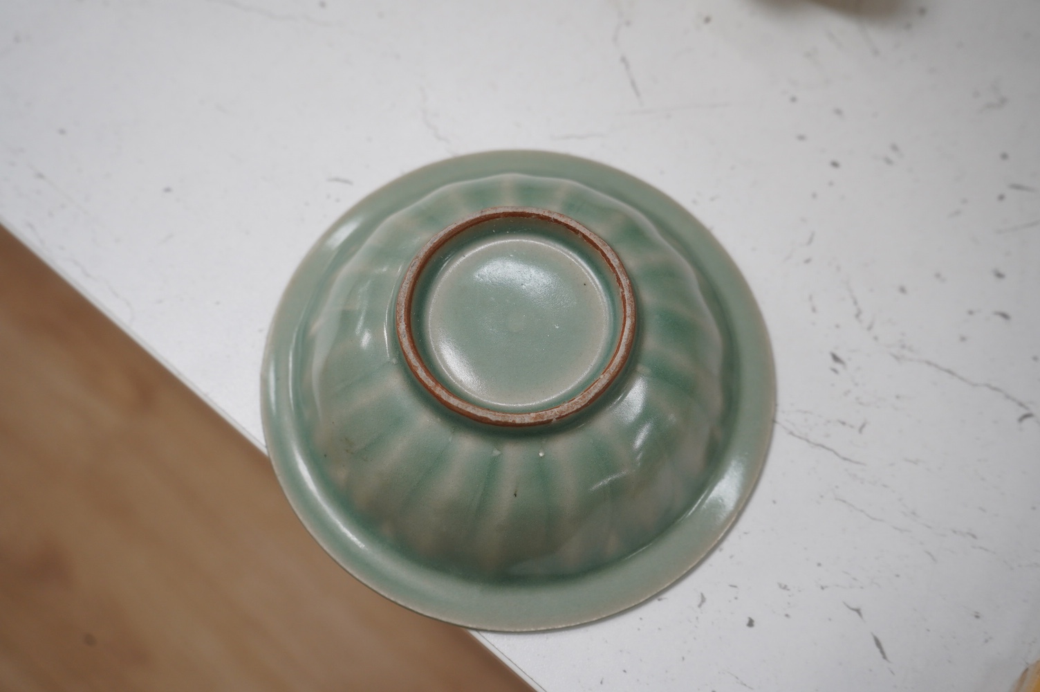 A Chinese cased celadon glazed 'twin fish' marriage dish, 13cm diameter. Condition - good